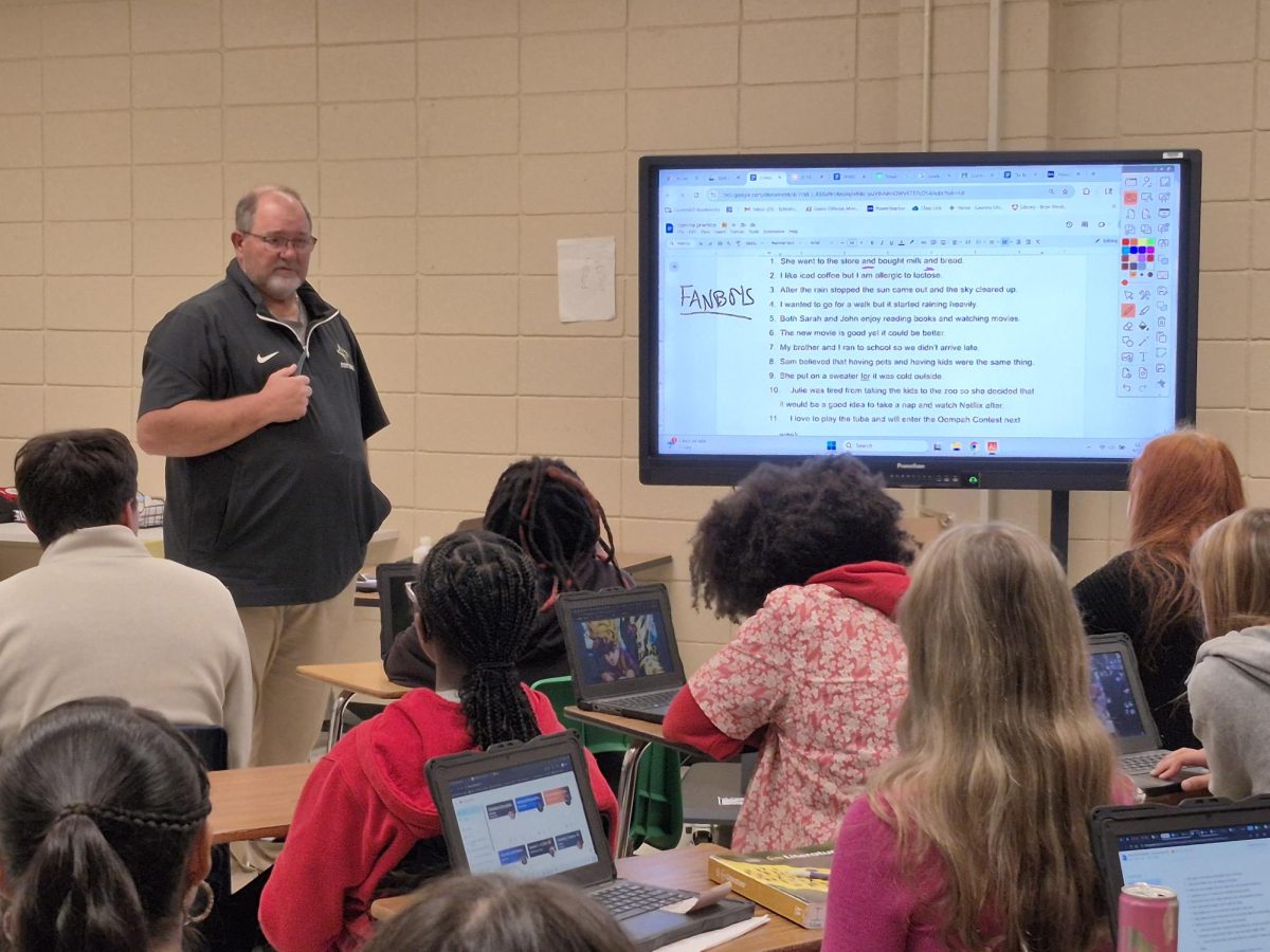 English teacher Jamie Childress teaches his English 3 Honors class grammar rules.