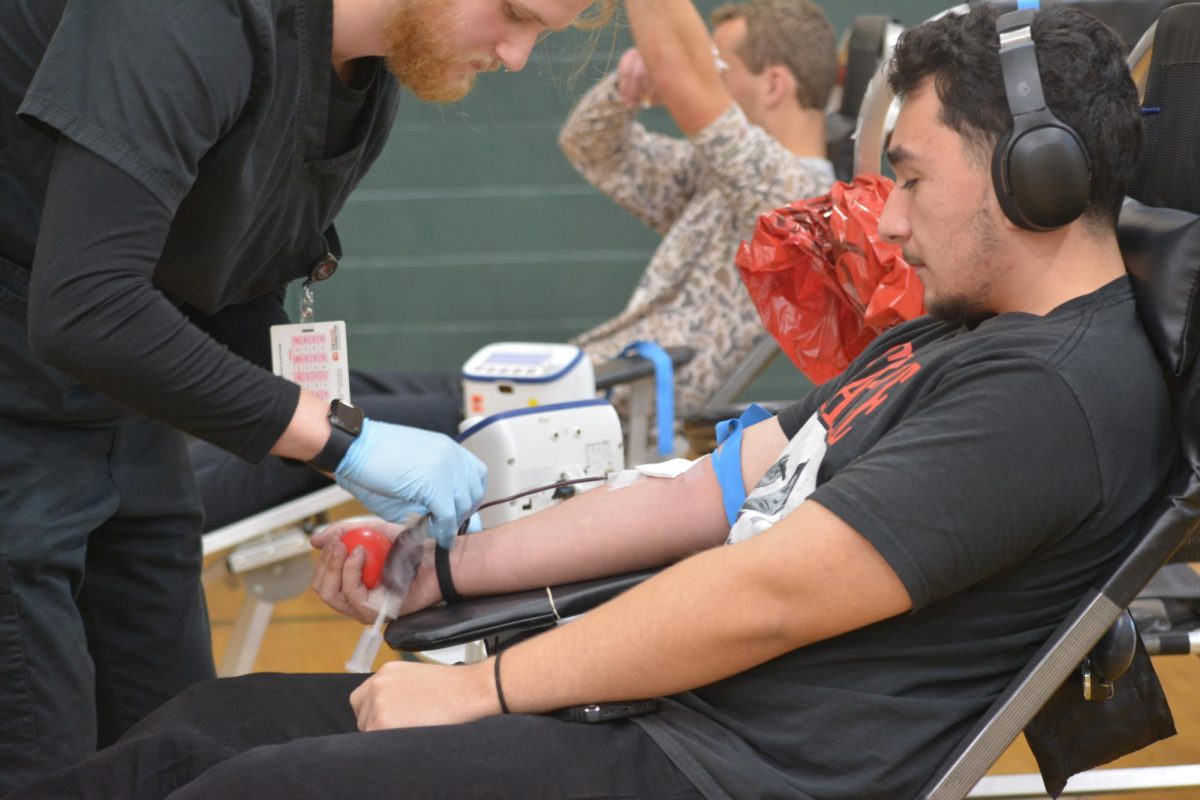 Junior Timman Balcazar gets his blood drawn by phlebotomist Jaylan Lions in the Aux Gym during the Jan. 15 blood drive.
